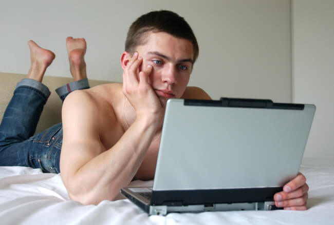 Shirtless man with a computer