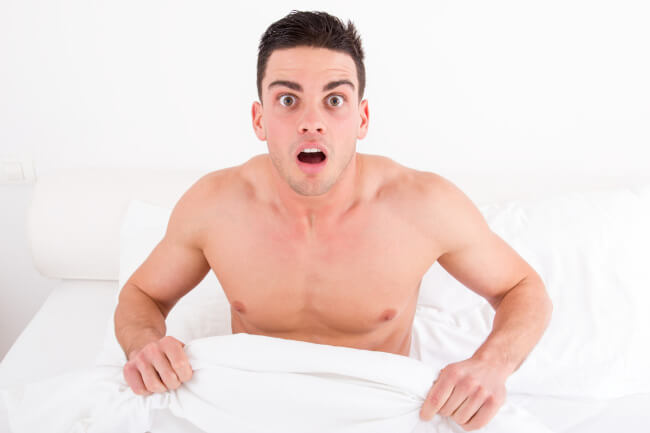 Surprised man shirtless in bed