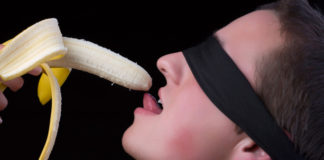 Man eating a banana blindfolded