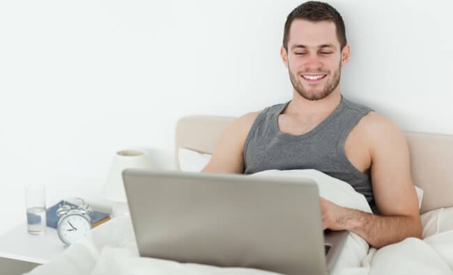 Man in bed with a laptop