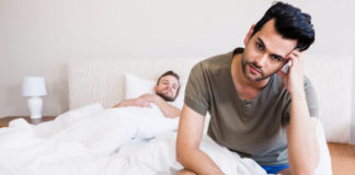 Two men angry in bed