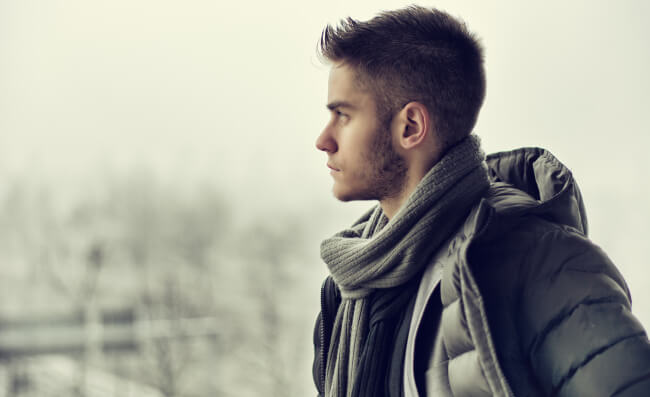 Young man outdoors thinking