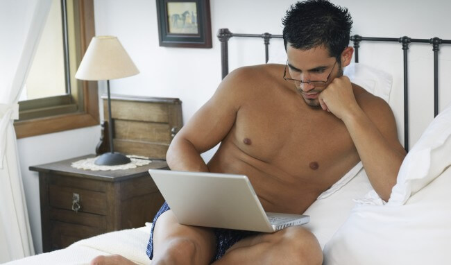 Man with a laptop in bed