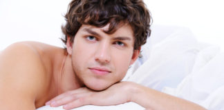 Shirtless man in bed