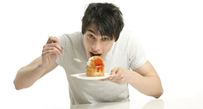 Man eating big cream cake