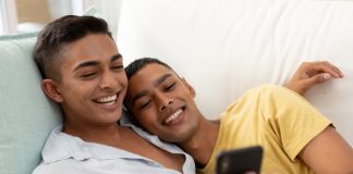 Gay couple with phone laughing