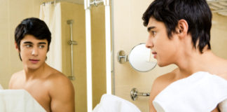 Man in shower in front of mirror