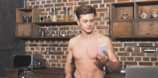 Shirtless man holding phone
