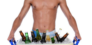 Shirtless man carrying beer